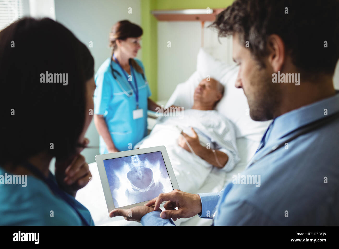 Male doctor and nurse looking at digital tablet Stock Photo