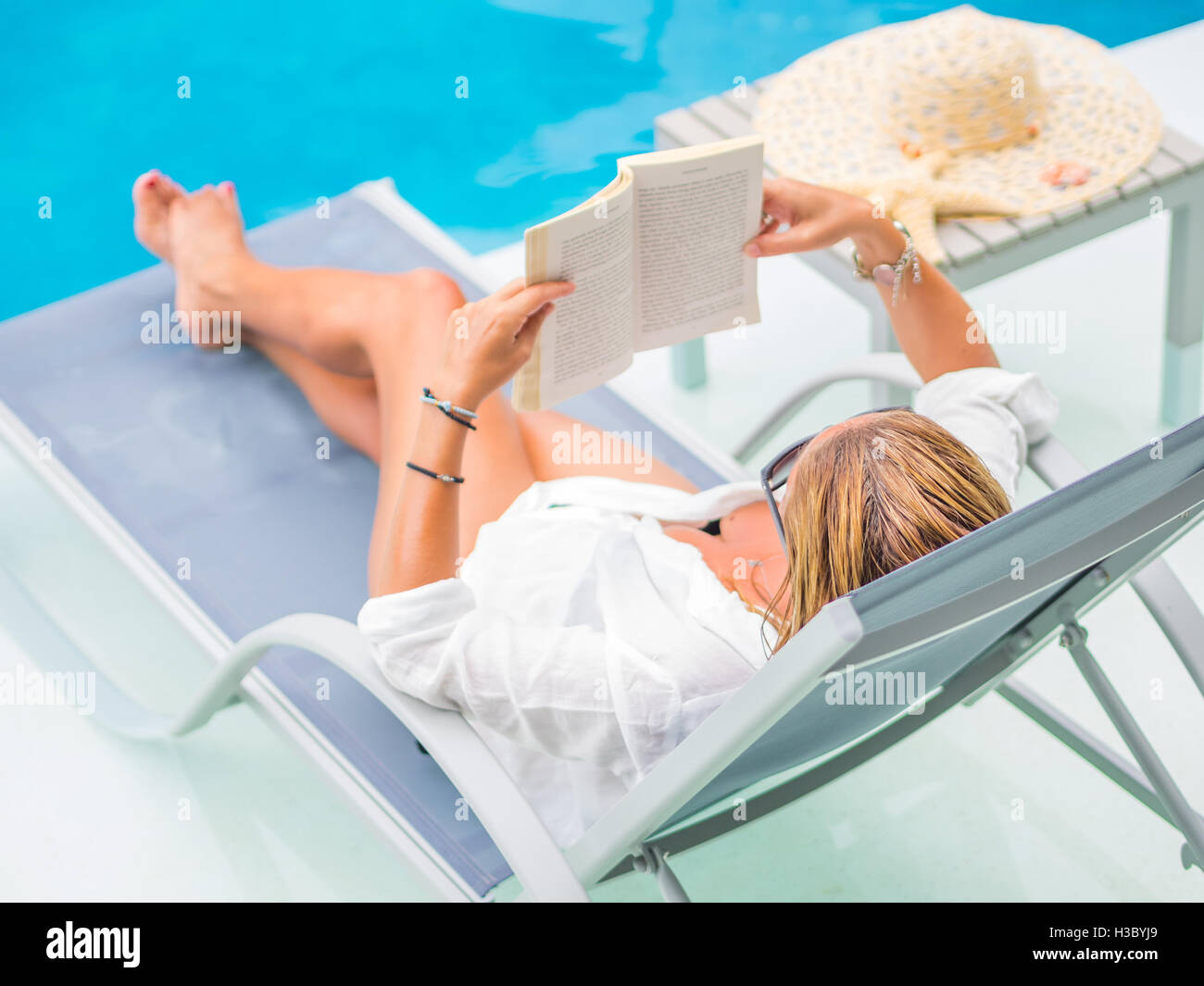 woman reading and relaxing near luxury swimming pool Stock Photo - Alamy
