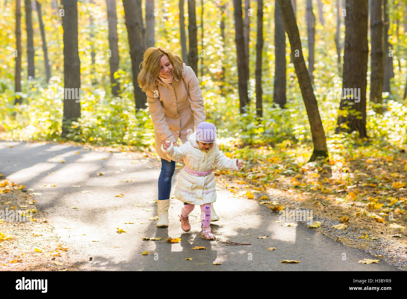 Young mother and her toddler girl have fun in autumn Stock Photo - Alamy