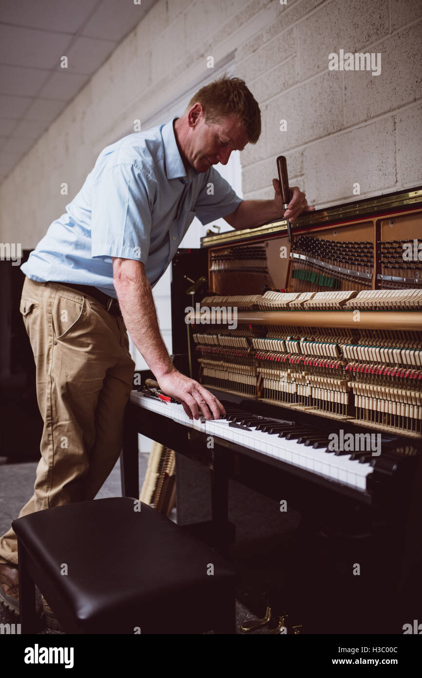 Piano technician repairing the piano Stock Photo