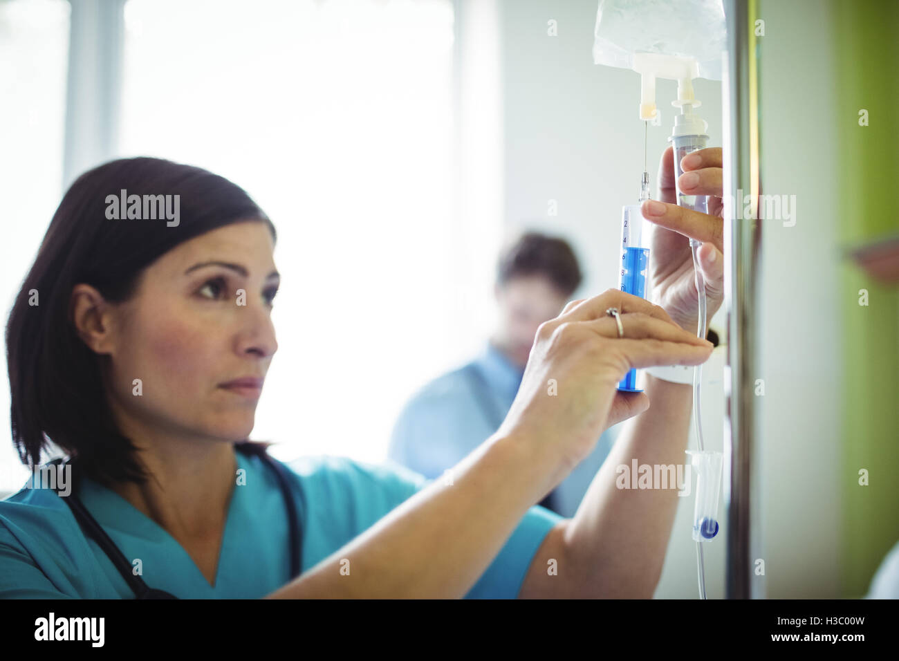 Nurse injecting medicine in infusion Stock Photo