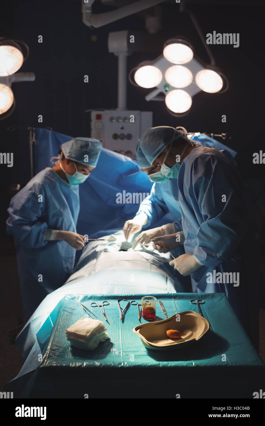 Surgeons performing operation in operation room Stock Photo