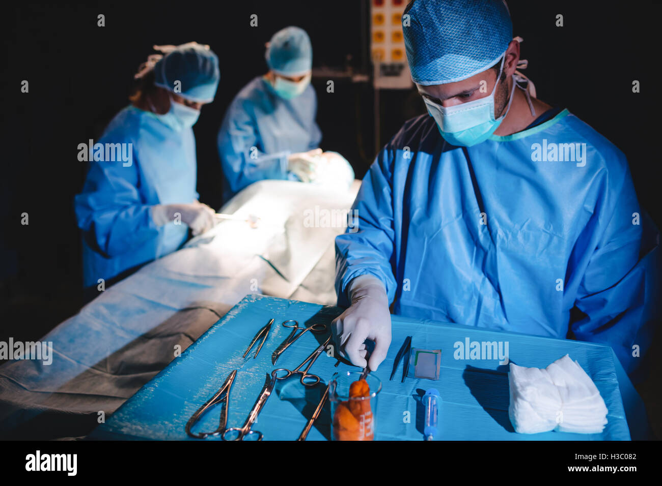Surgeon taking a scissors from tray Stock Photo