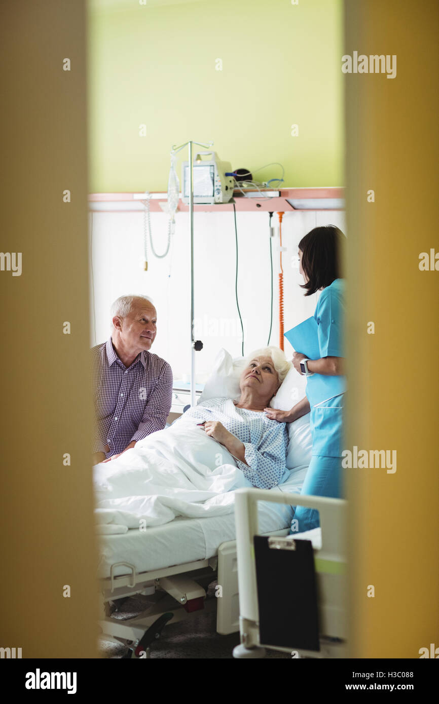 Senior couple interacting with nurse Stock Photo
