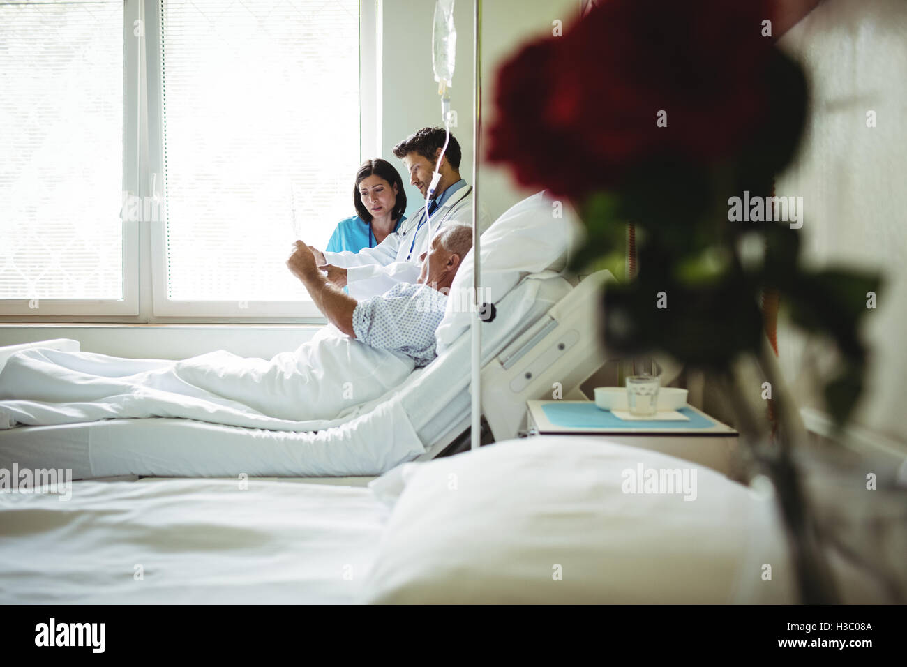 Doctor and nurse interacting over x-ray report with patient Stock Photo