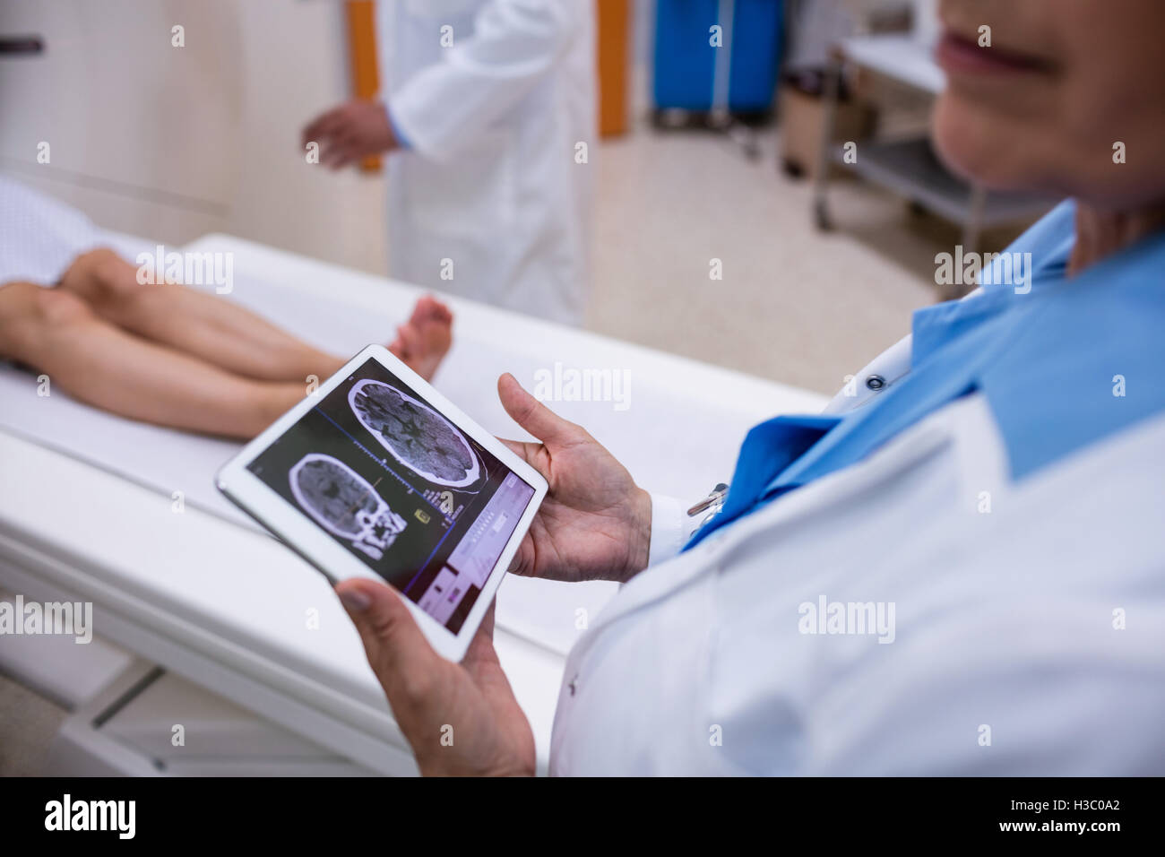 Doctor looking at brain mri scan on digital tablet Stock Photo