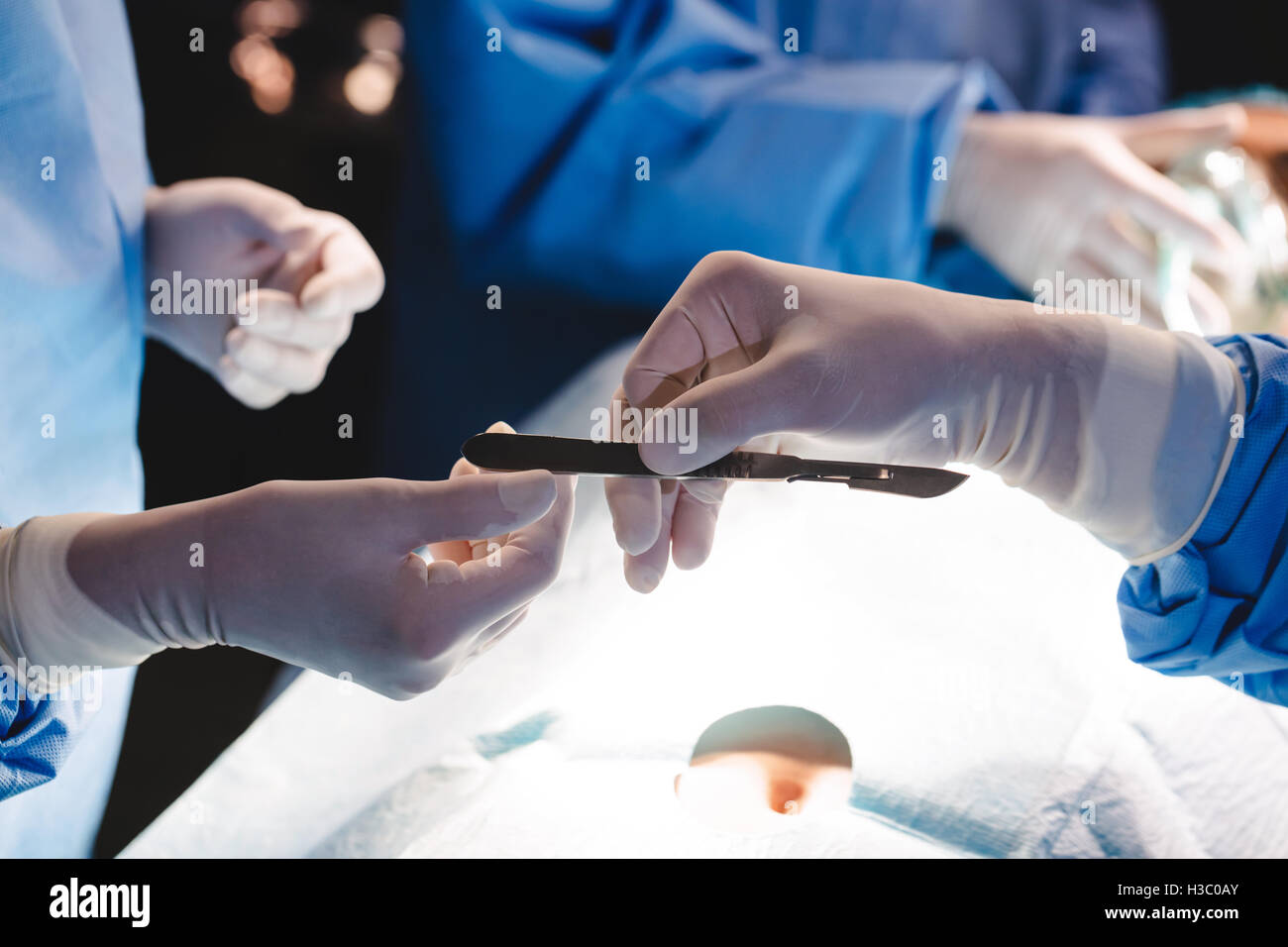 Surgeons giving operation blade to colleague in operation room Stock Photo Alamy
