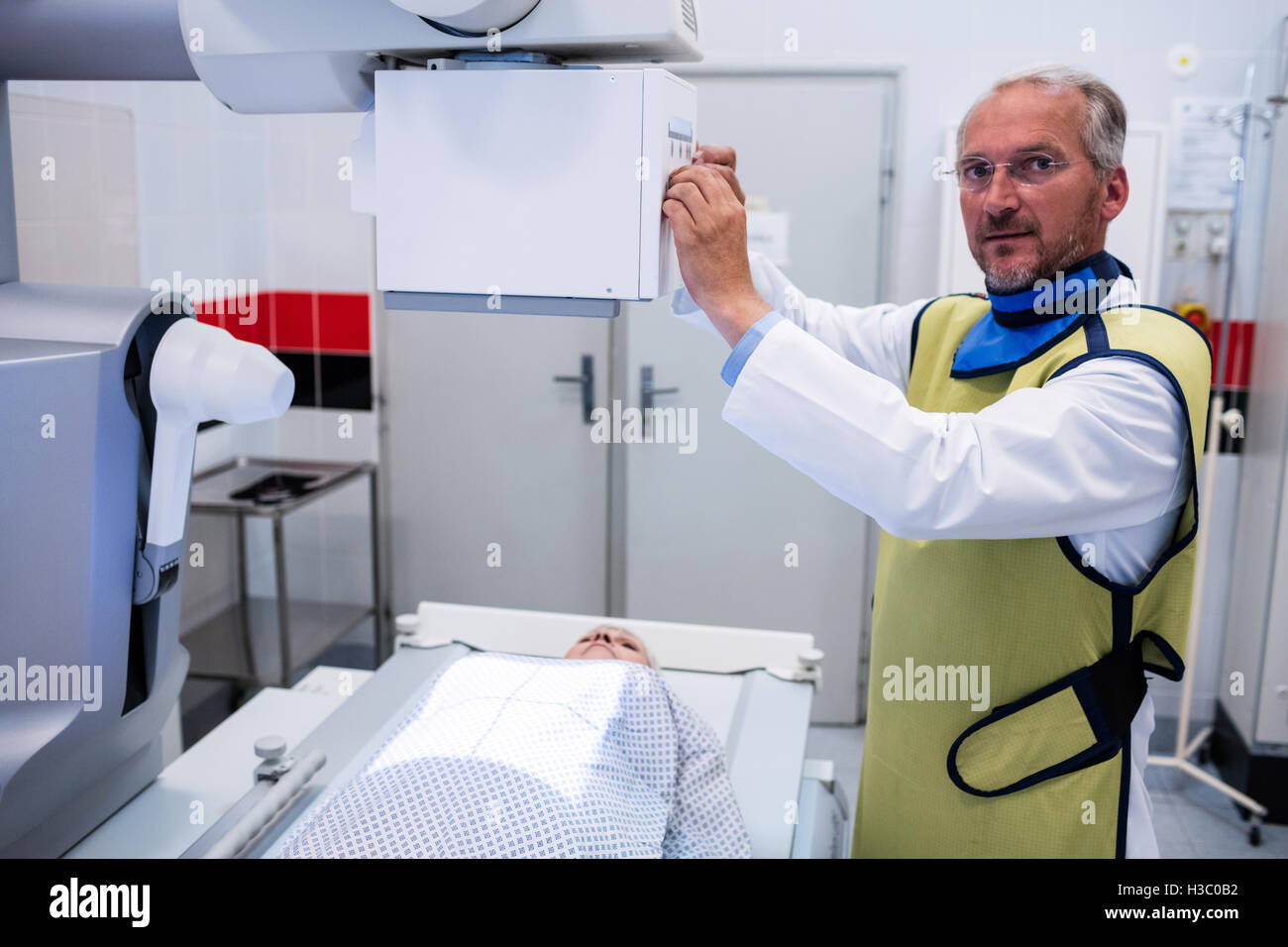 Doctor using x-ray machine to examine patient Stock Photo