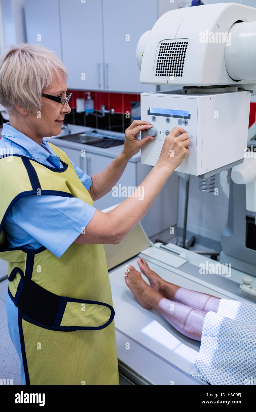 Doctor using x-ray machine to examine patient Stock Photo