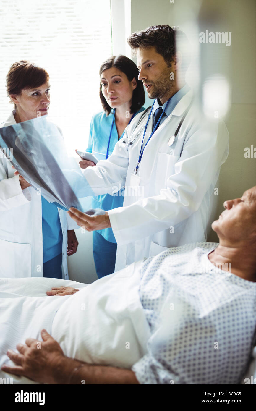 Doctors interacting over x-ray report with patient Stock Photo