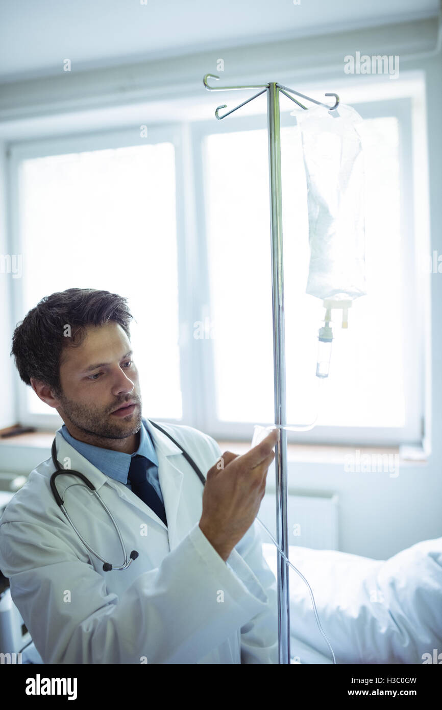 Male doctor checking a saline drip Stock Photo