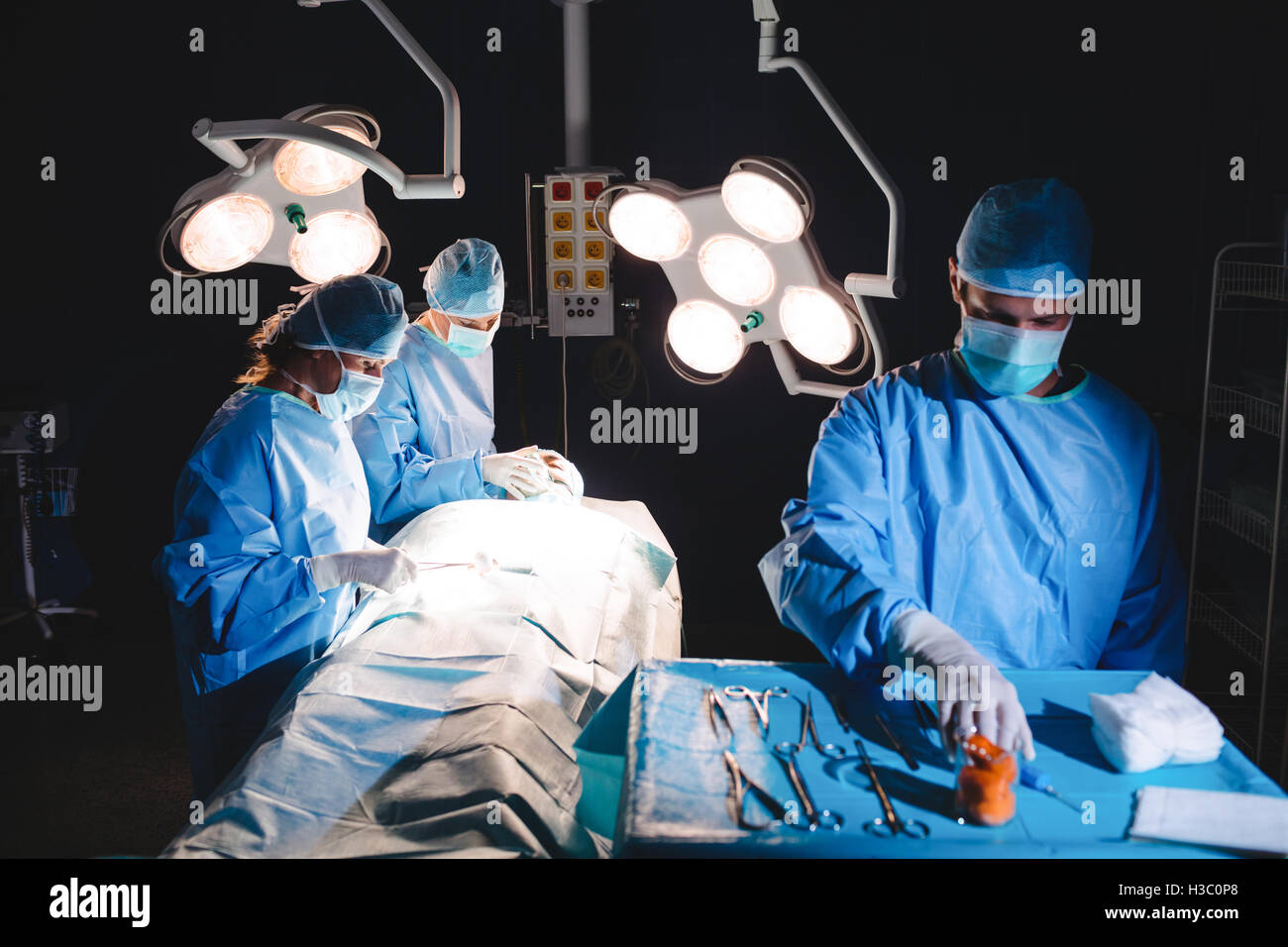 Surgeon taking a scissors from tray Stock Photo