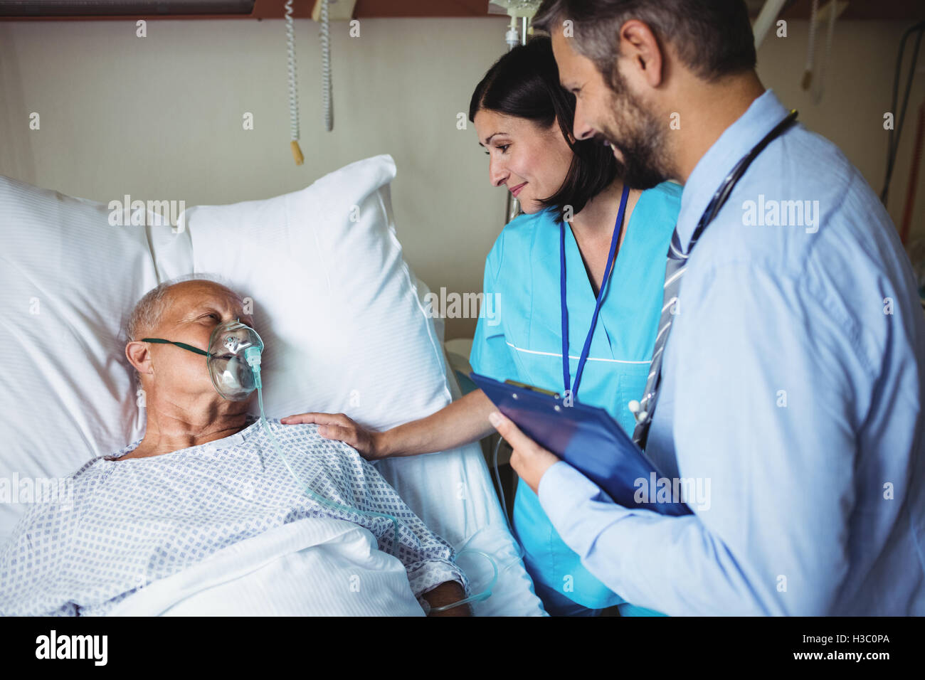 Nurse consoling senior patient with doctor Stock Photo