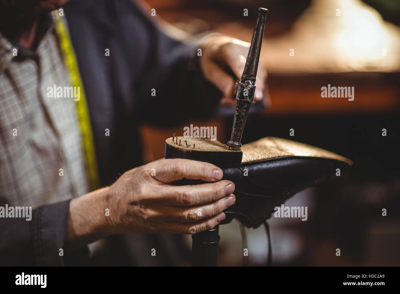 Shoemaker hammering on a shoe Stock Photo - Alamy