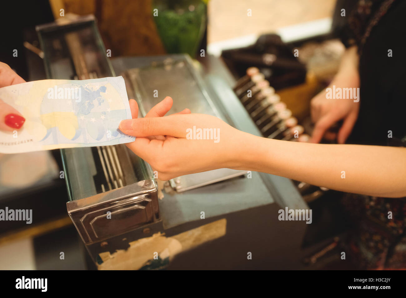 Female cashier accepting a payment at counter Stock Photo