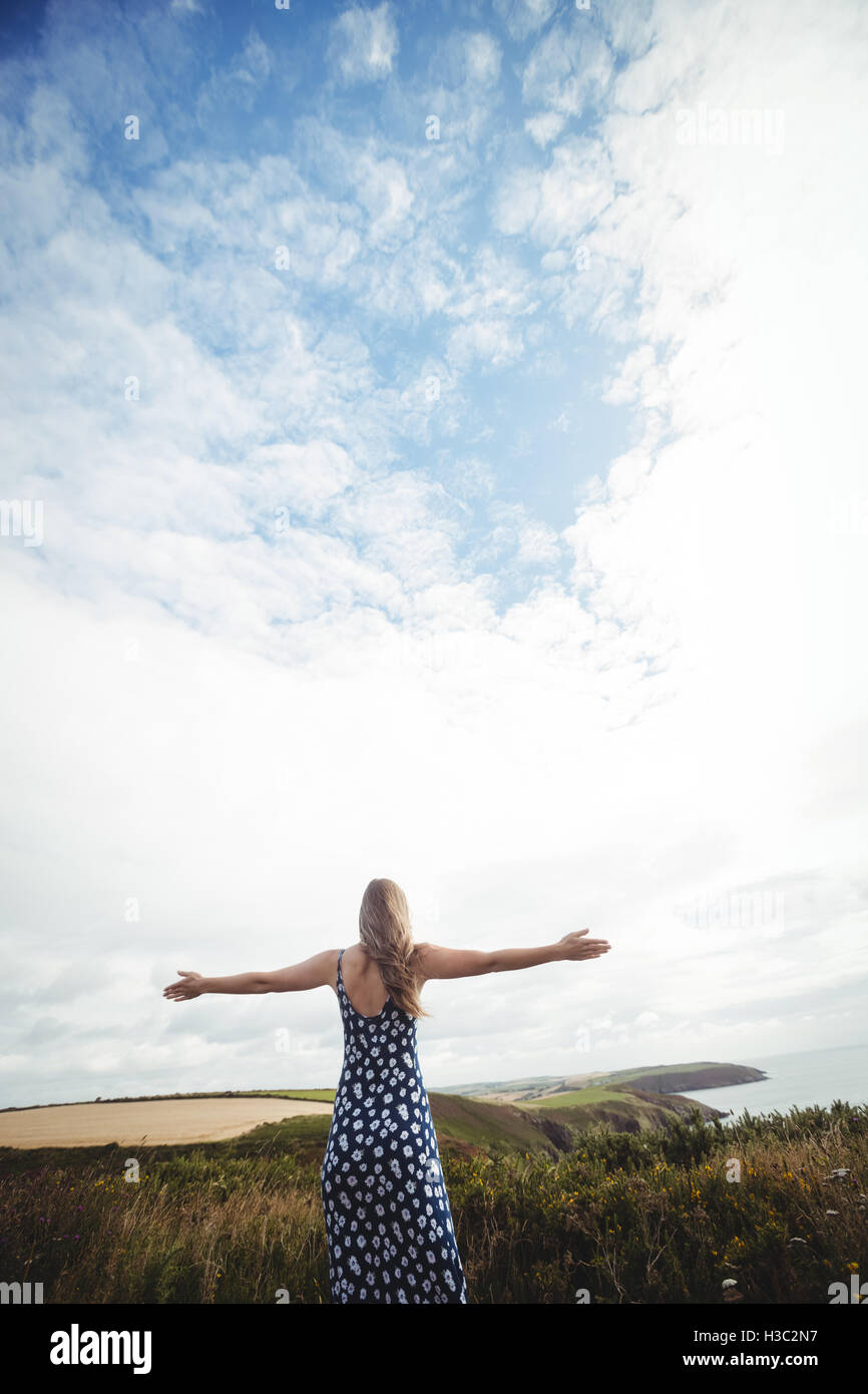 Rear view woman standing with arms outstretched Stock Photo - Alamy