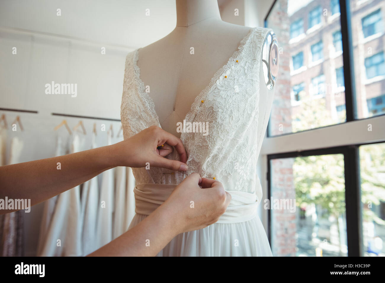 Female fashion designer adjusting the dress on mannequin Stock Photo ...