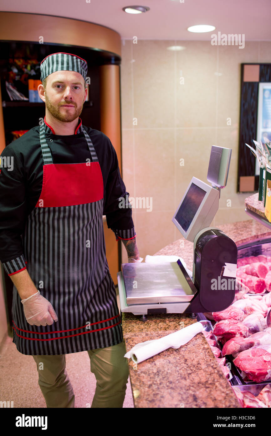 Portrait of butcher standing at counter Stock Photo