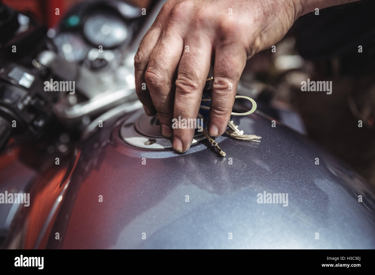 Mechanic closing a fuel tank of motor bike Stock Photo Alamy