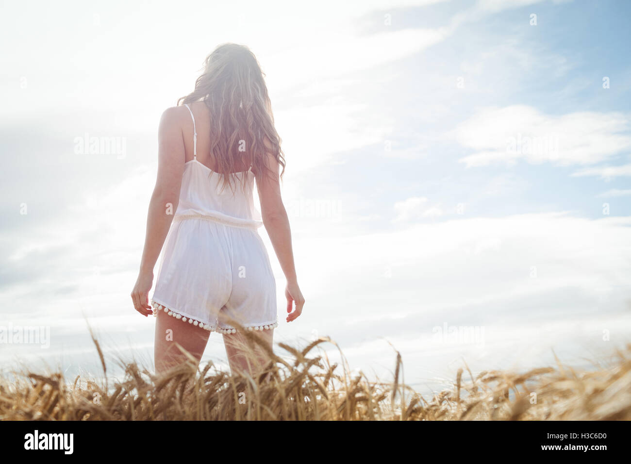 Rear view of woman standing in wheat field Stock Photo - Alamy