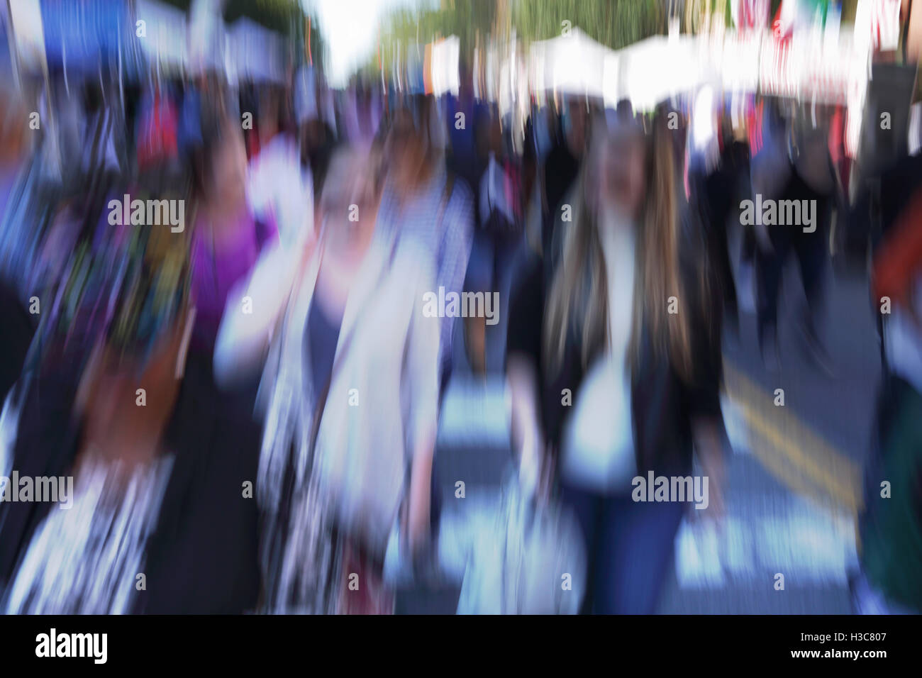 Blurred crowd of people walking down a street fair in New York City ...