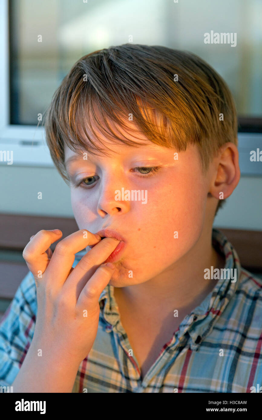 young boy licking his fingers Stock Photo