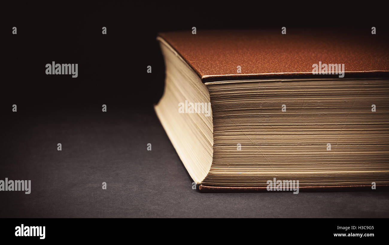 Closeup view on an old closed book, details of paper and leatherette cover. Stock Photo
