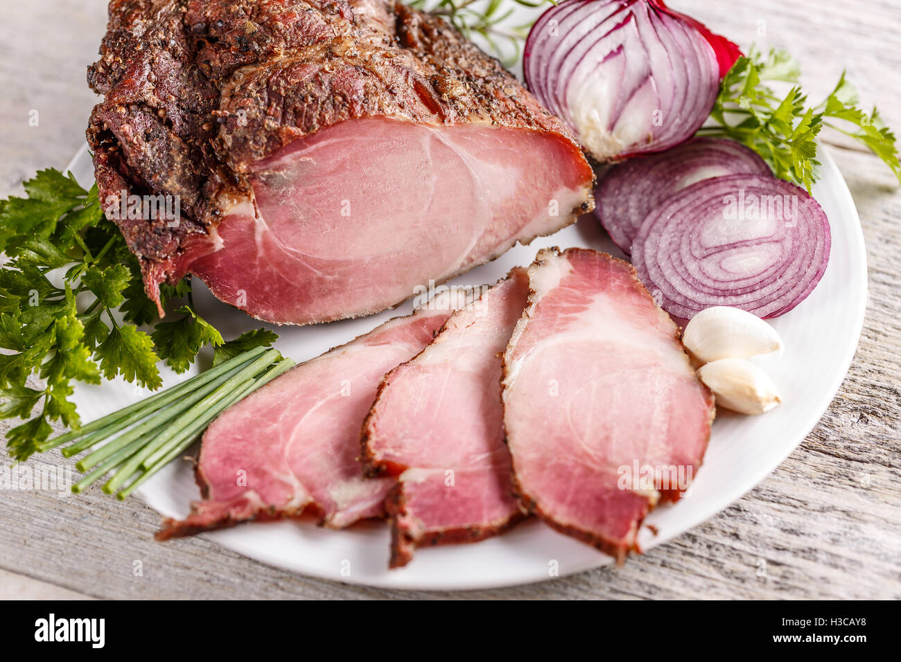 Smoked pork loin with spices on white plate Stock Photo