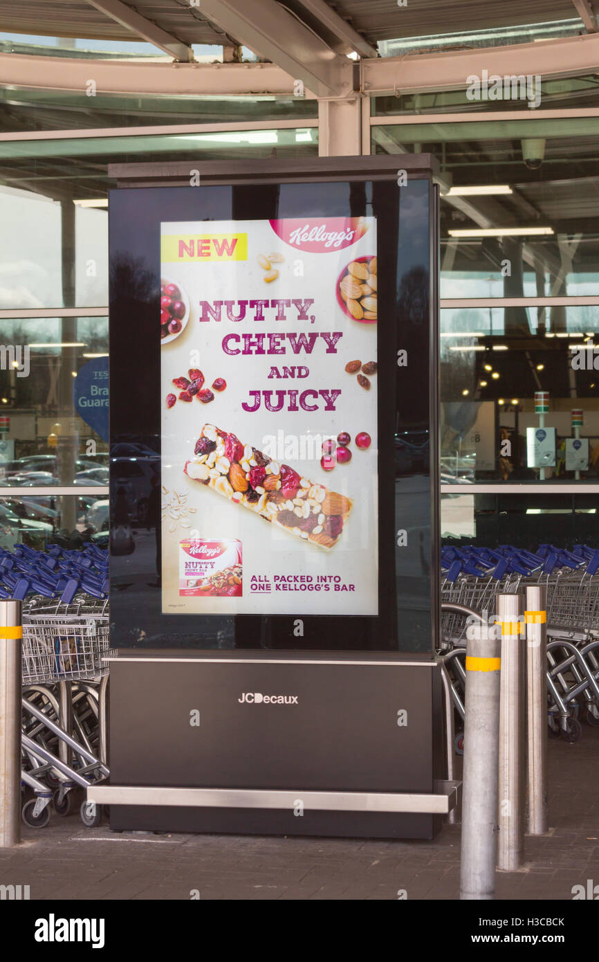 A JC Decaux vertical format HD digital advertising screen outdoors near the entrance to the Tesco Extra store in Horwich. Stock Photo