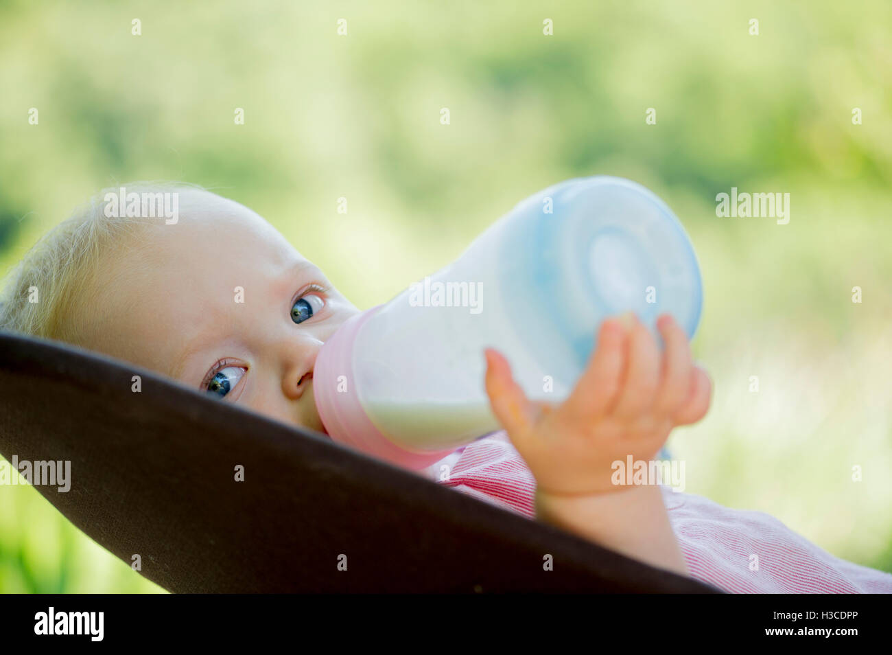 Infant drinking milk from bottle Stock Photo