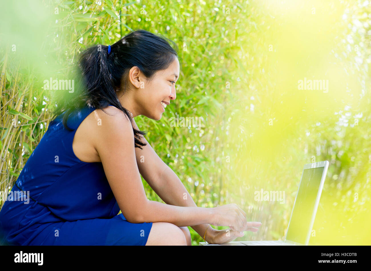 Woman using laptop computer outdoors Stock Photo