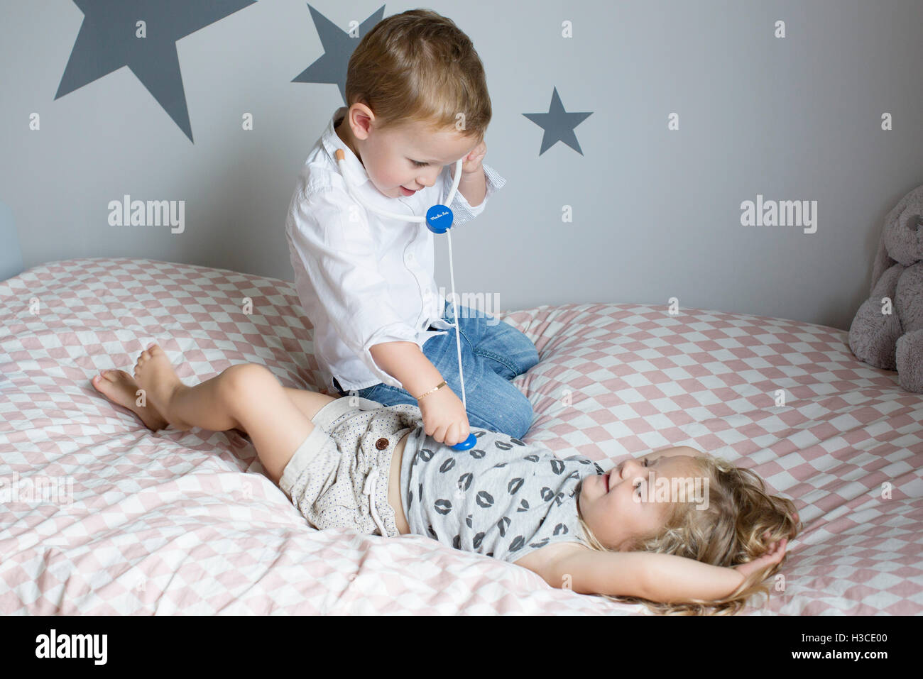 Children playing doctor with toy stethoscope Stock Photo