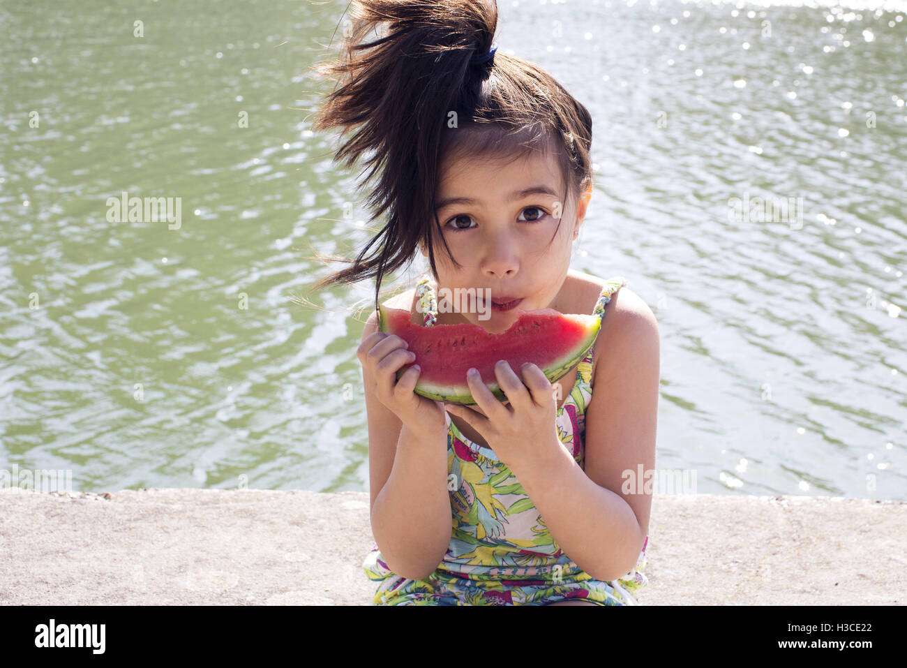 Girl eating watermelon outdoors Stock Photo
