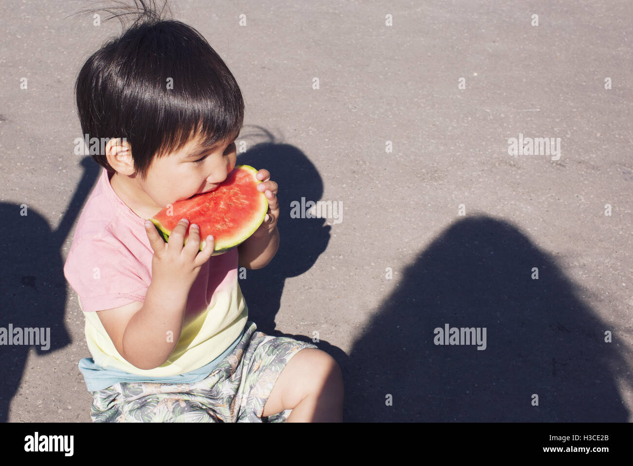 Little boy eating watermelon outdoors Stock Photo