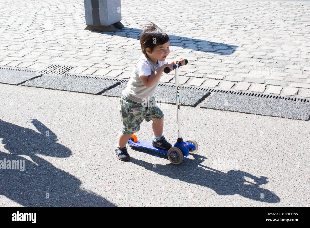 Little boy riding push scooter Stock Photo