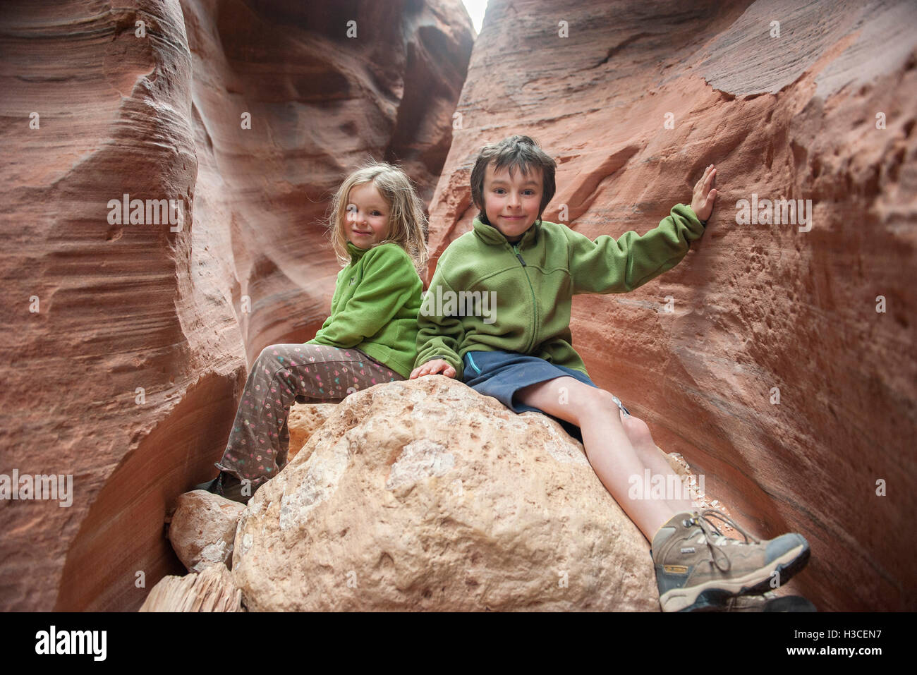 Children sitting on rock formation in Utah, USA Stock Photo