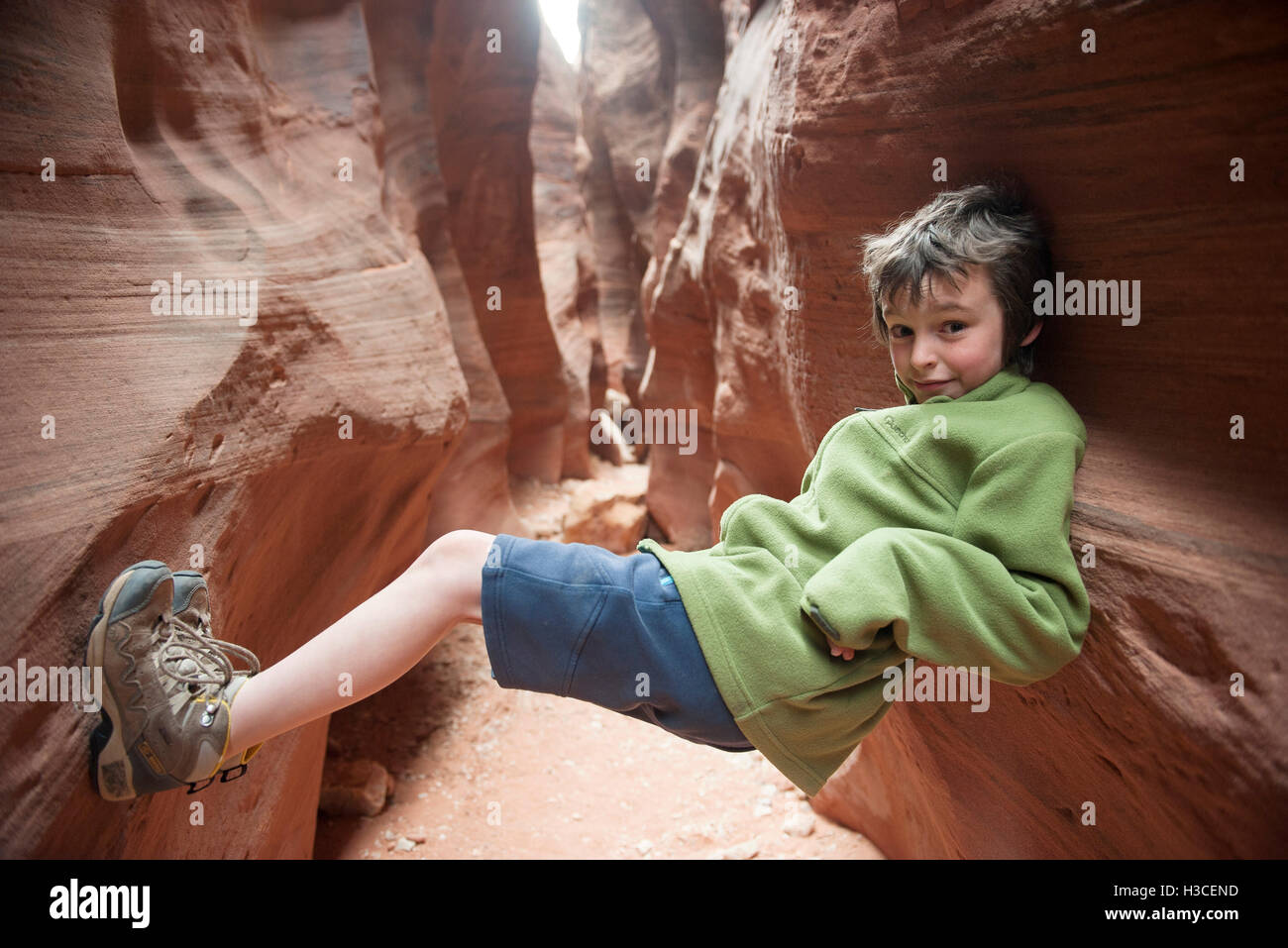 Boy balancing in narrow slot canyon Stock Photo