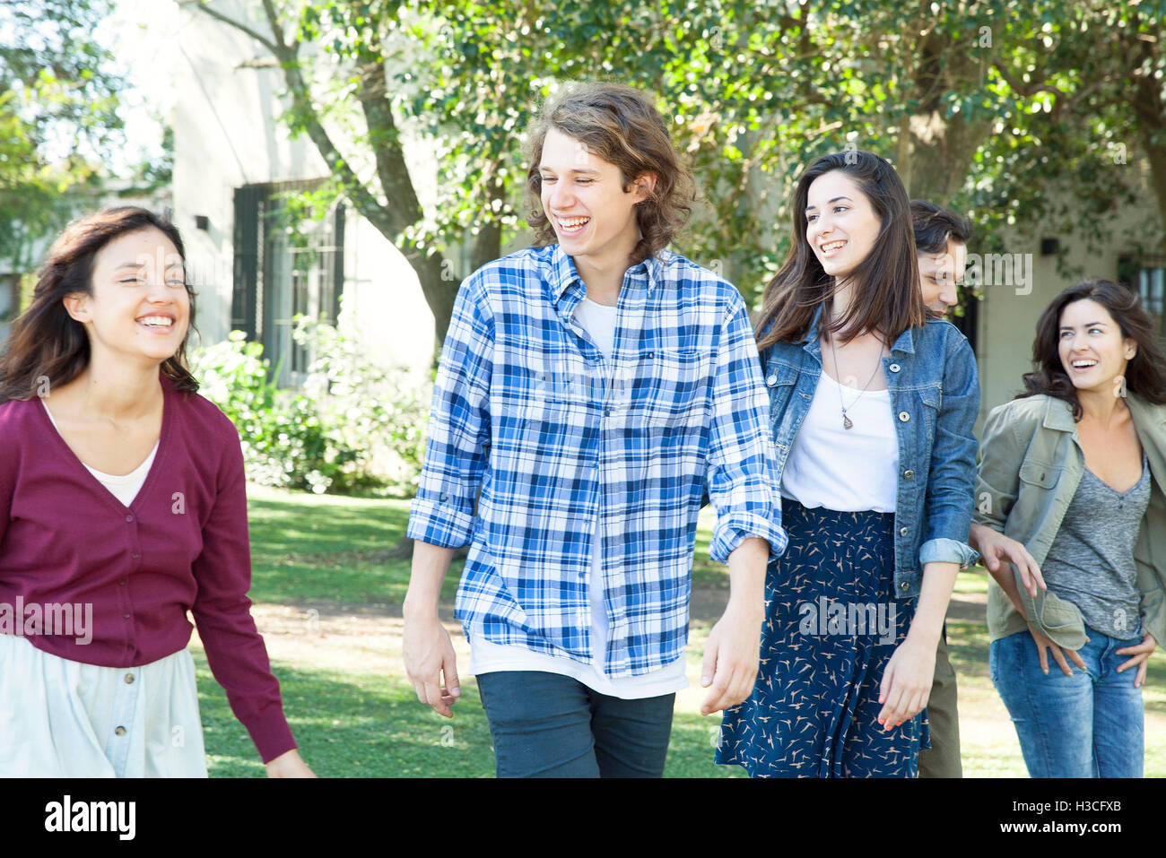 College friends walking together outdoors Stock Photo