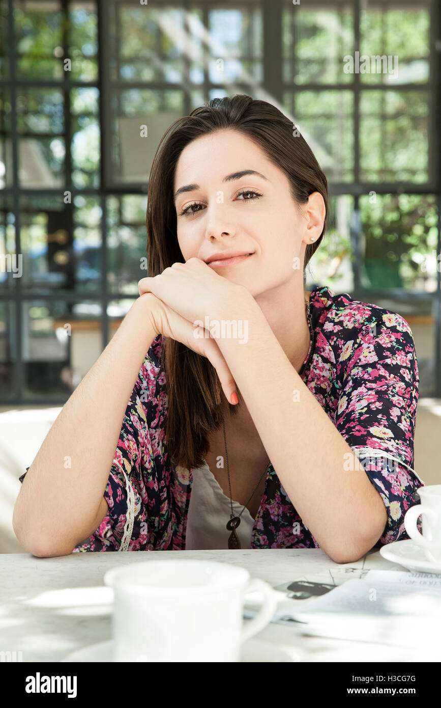 Young woman at breakfast table outdoors Stock Photo