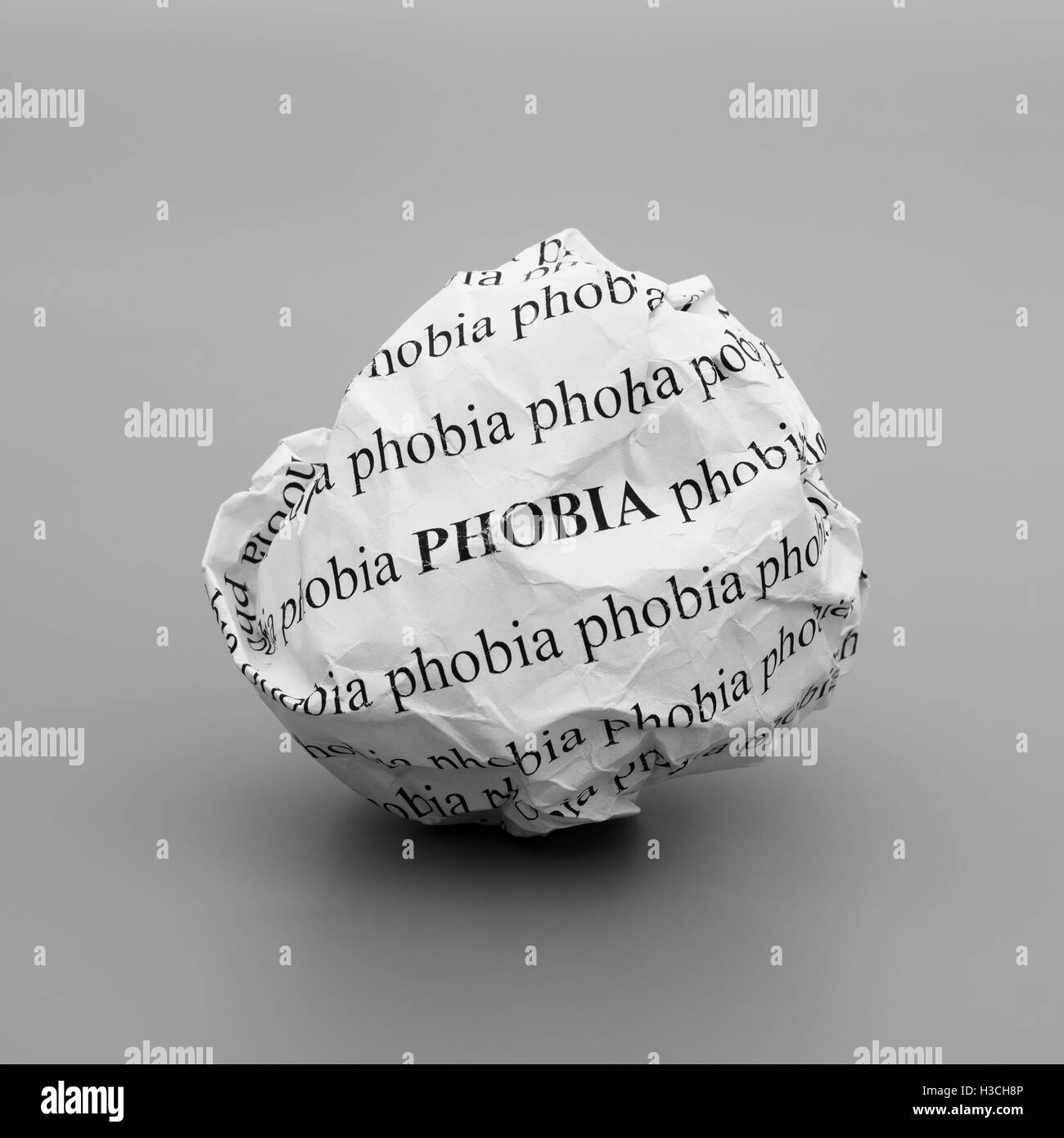 Crumpled paper ball with words Phobia on gray background Stock Photo