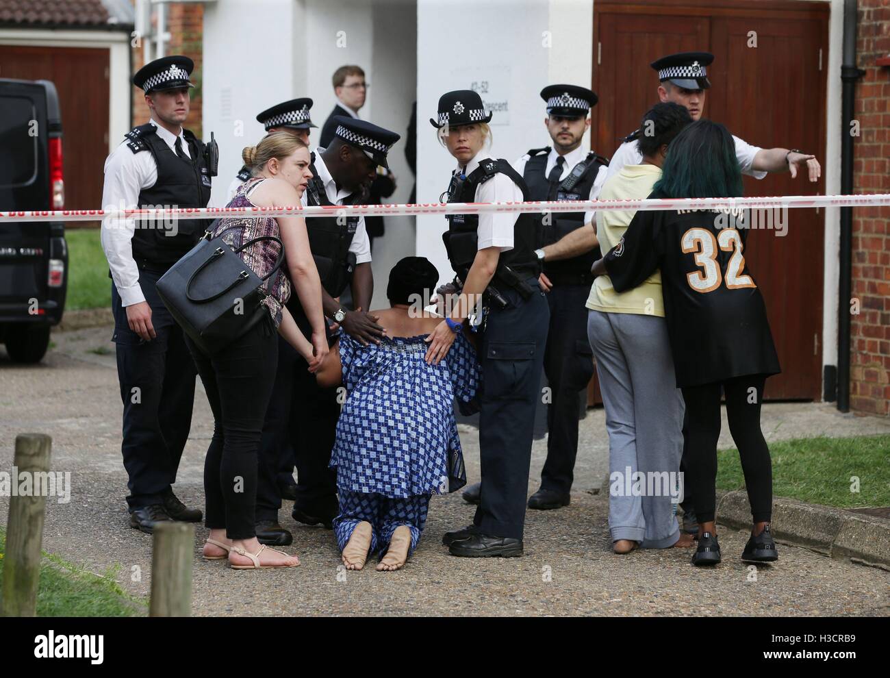 Family members outside flats in in Elmshurst Crescent in East Finchley, north London where Anny Ekofo, 52, and her nephew Bevely, 21, where found dead with gunshot wounds. Stock Photo