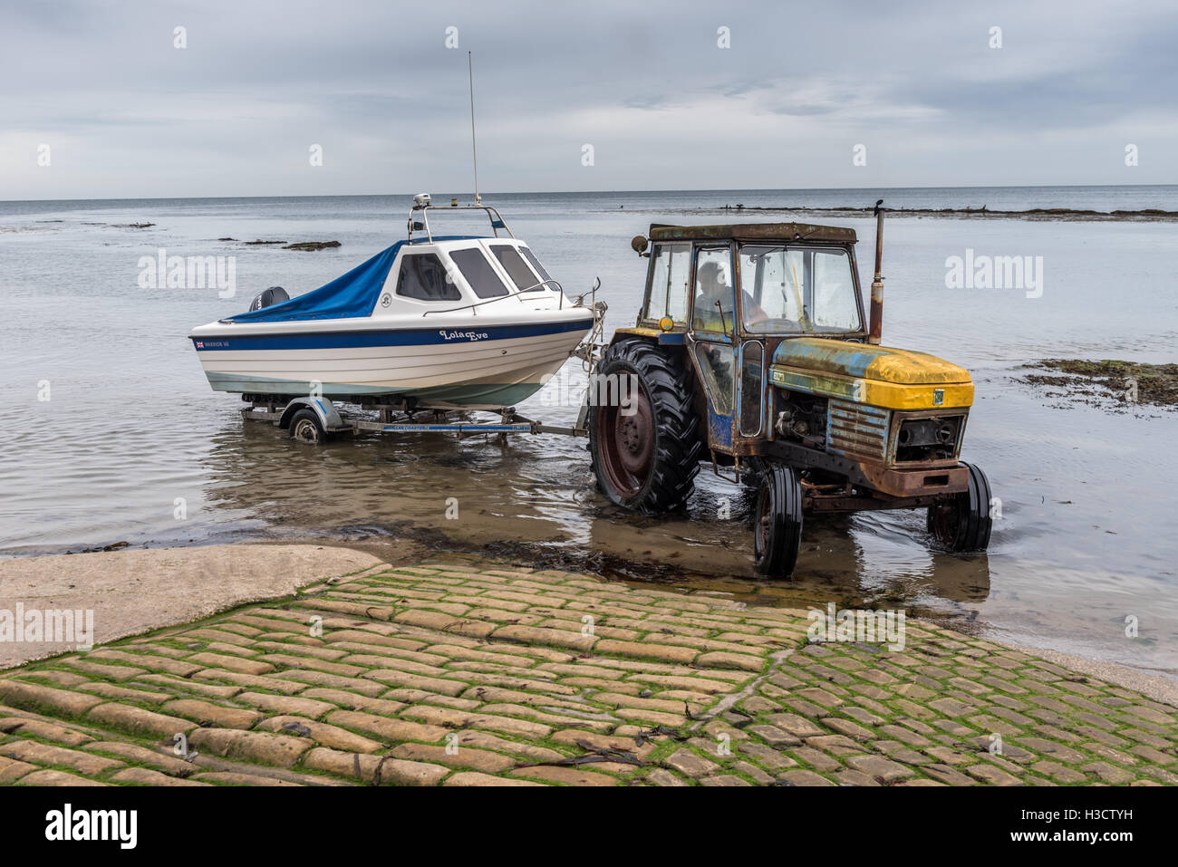 Bring the fishing boat ashore at Robin Hood's Bay Yorkshire Stock Photo