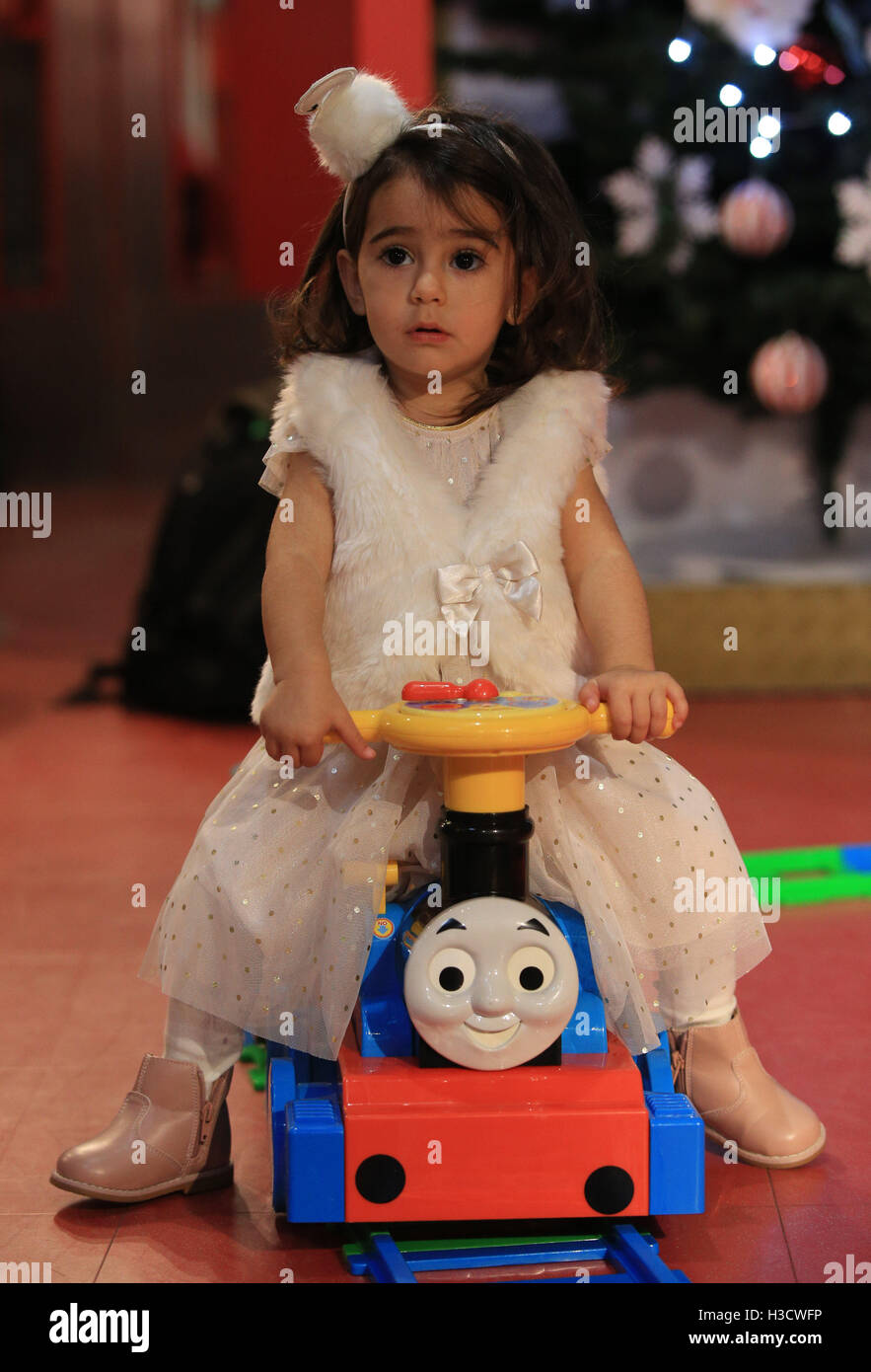 Esma Akar, two, rides a Thomas & Friends Battery Operated Train at Hamleys in London, as it is one of the toy store's predicted Fabulous Five for Christmas 2016. Stock Photo
