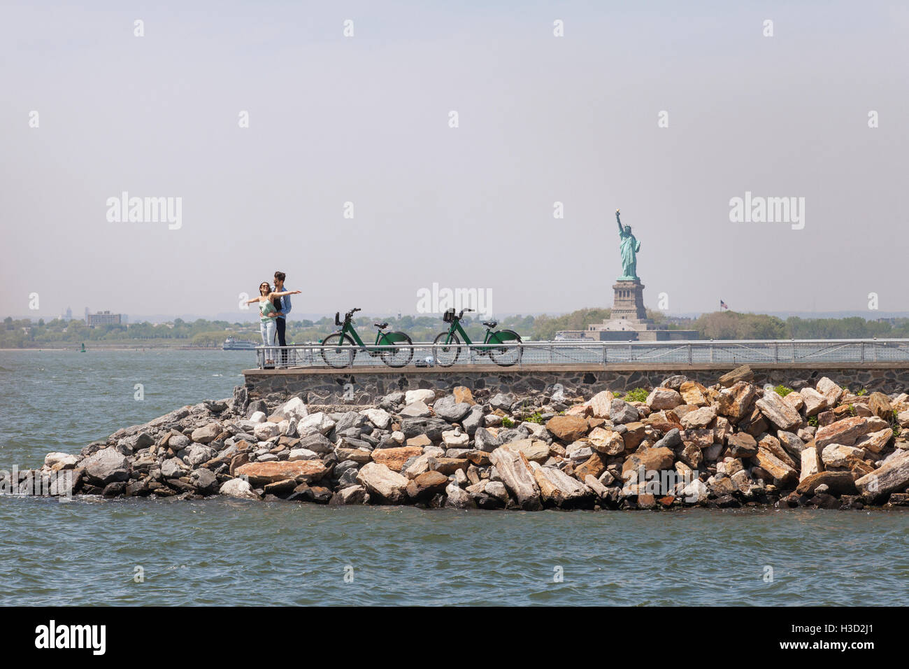 Couple enjoying on observation point with Statue of Liberty in background against clear sky Stock Photo