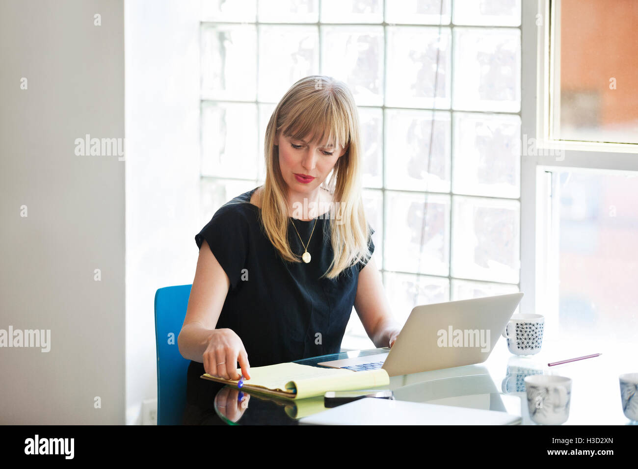 businesswoman using laptop on table in creative office Stock Photo
