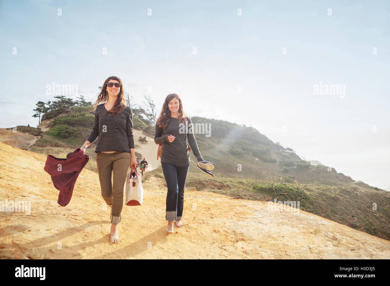 Happy women walking on mountain against sky Stock Photo