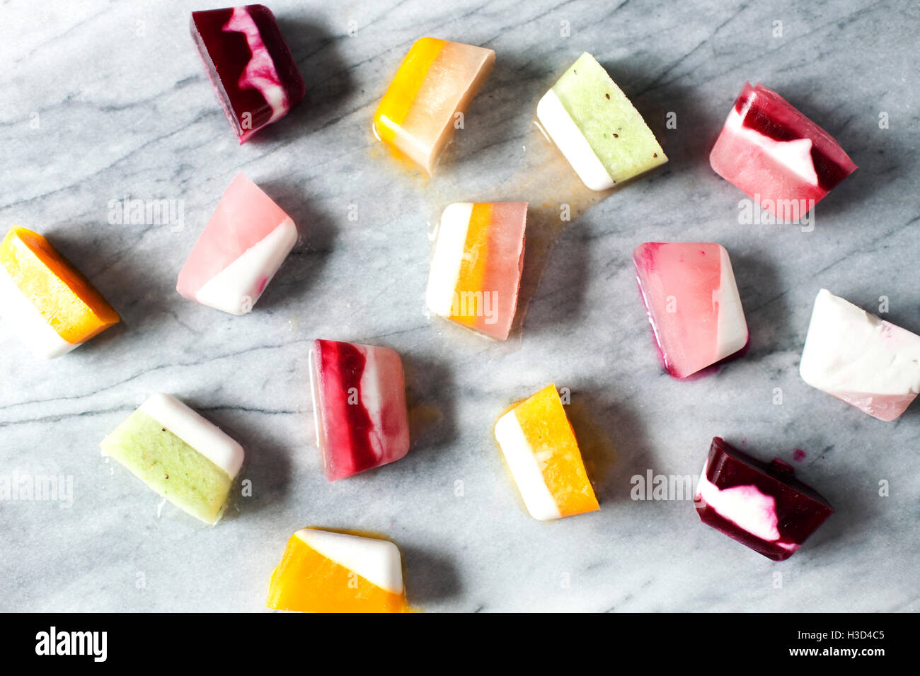 Overhead view of flavored ice cubes on marble counter Stock Photo