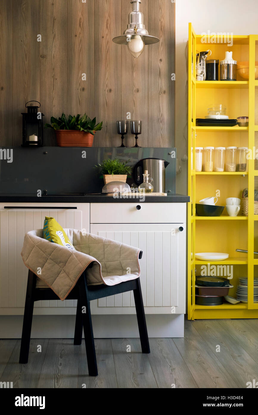 Chair and yellow cabinet in domestic kitchen Stock Photo