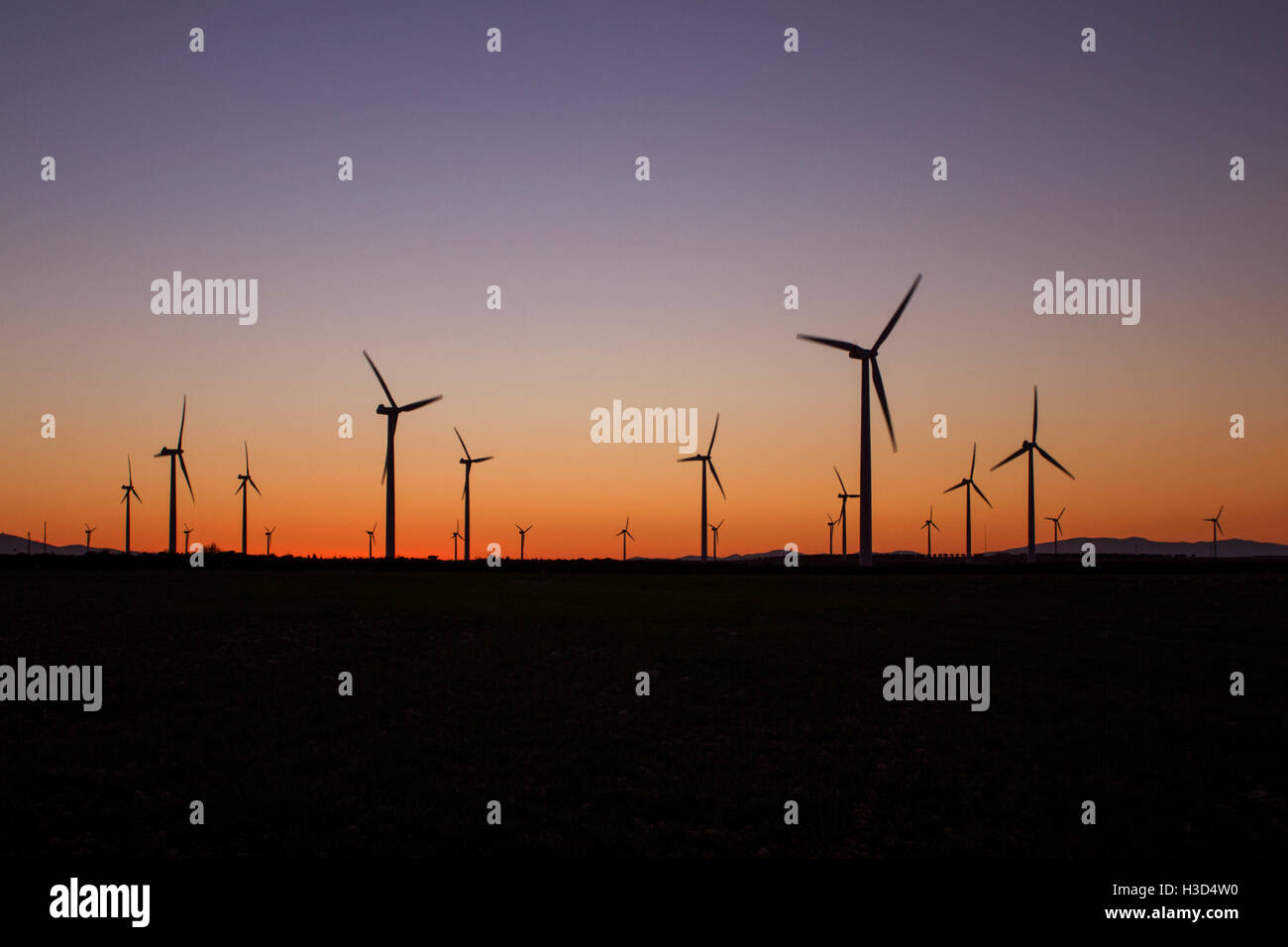 Silhouette wind turbines on field against clear sky during sunset Stock ...