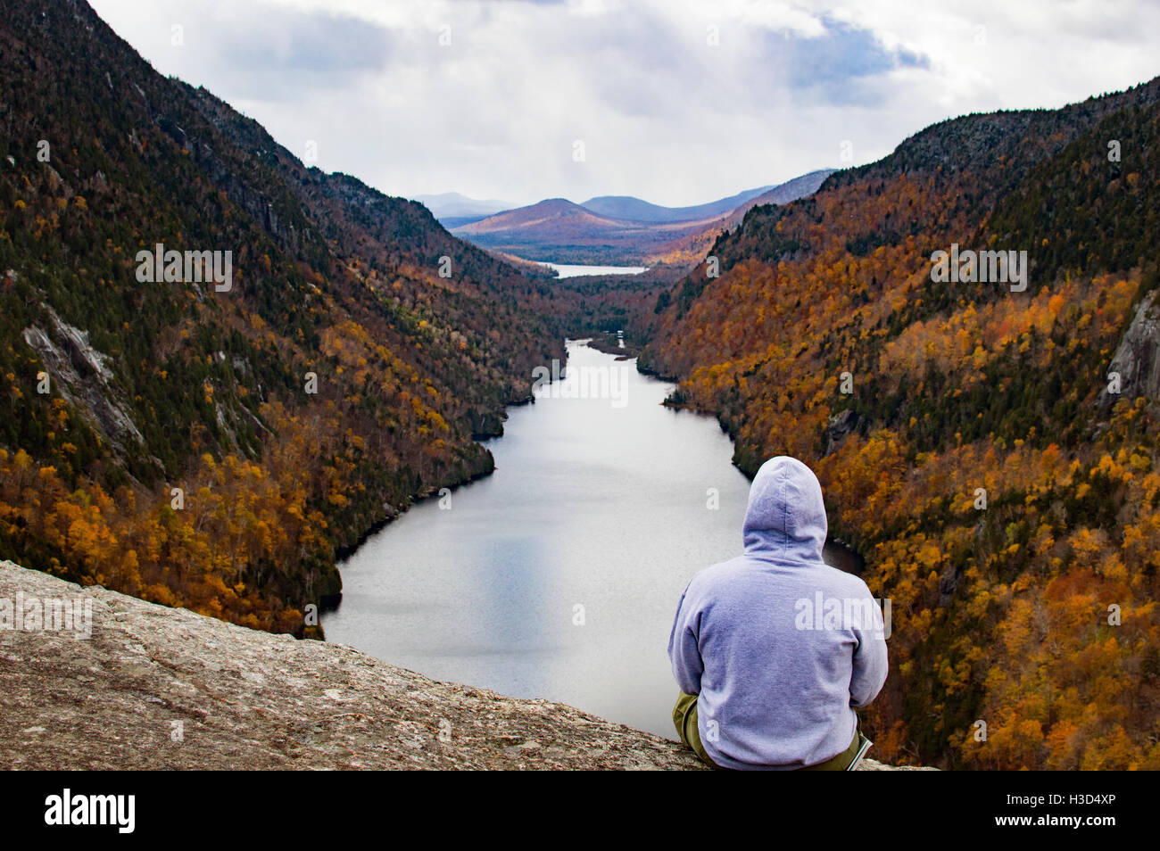 Rear view of man sitting on mountain during autumn Stock Photo